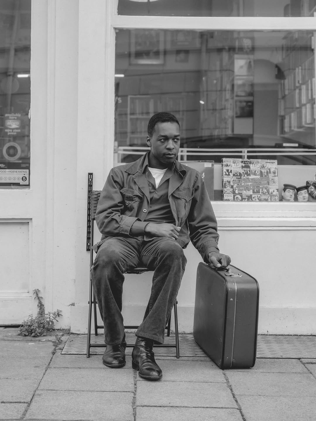 Jalen in black and white with a suitcase