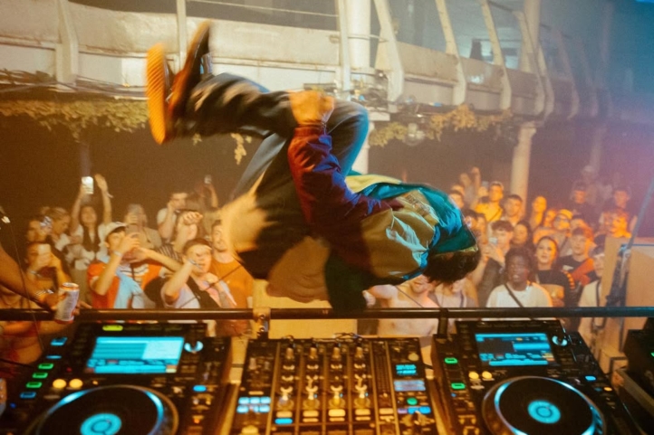 DJ doing a jump flip over the DJ booth / decks